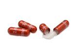 three red capsules are shown, one is open and has white powder inside