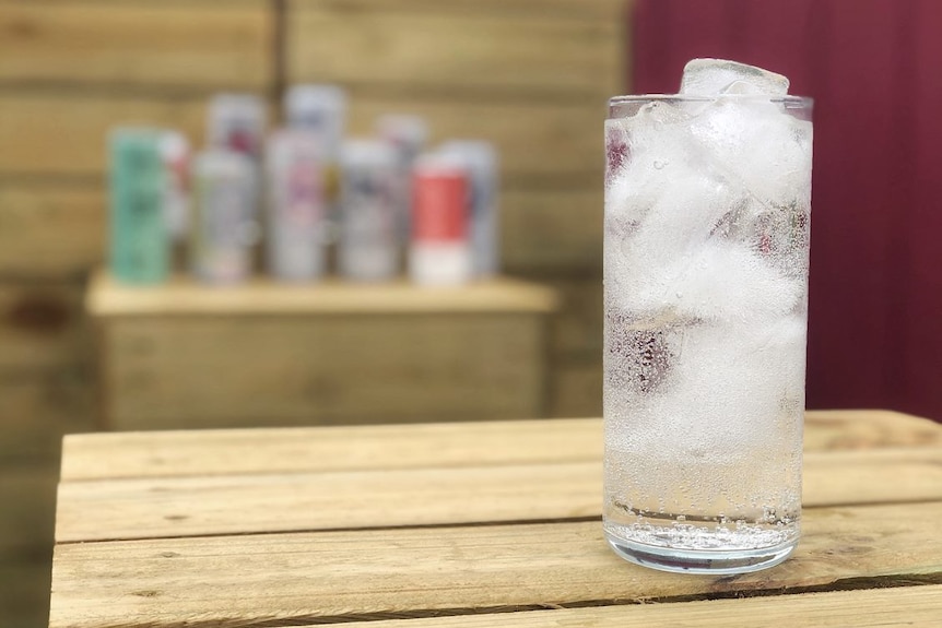 A glass containing a clear liquid and ice