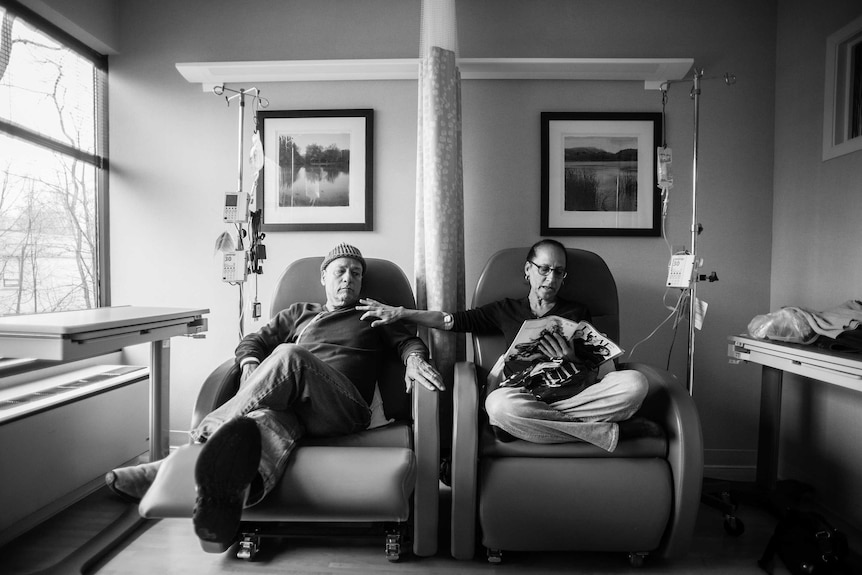 A man sits beside his wife as they get their weekly chemotherapy treatments.