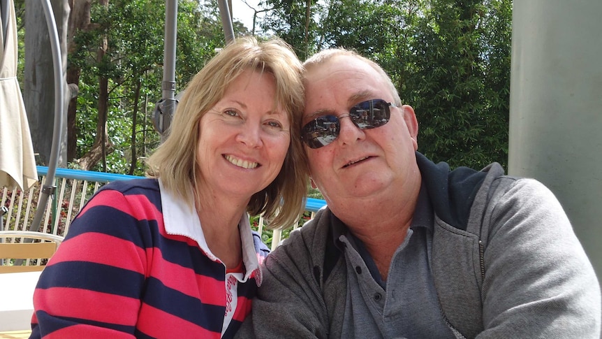 A man and a woman pose for a photo with their heads close together