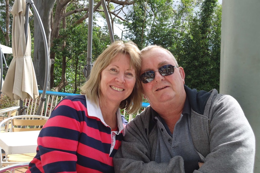 A man and a woman pose for a photo with their heads close together