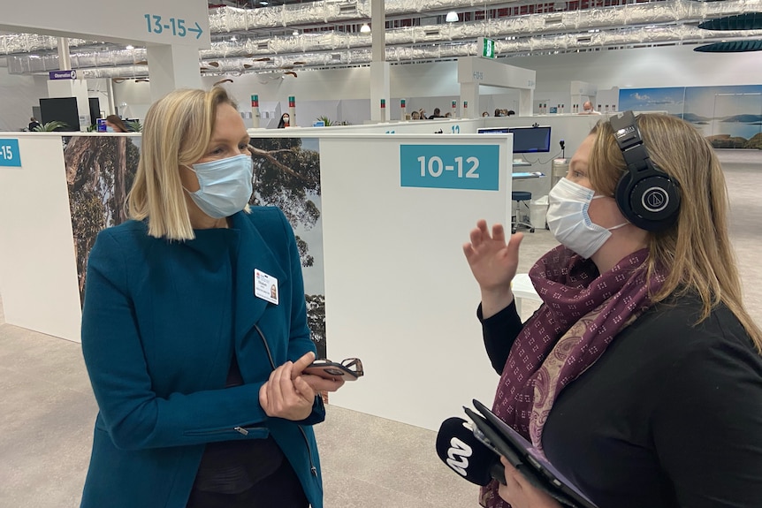 Two women in masks pictured inside a medical facility