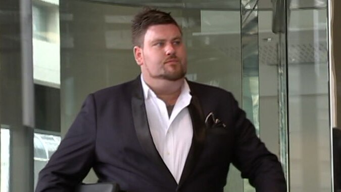 A mid shot of James Bartlett walking outside the Perth Magistrates Court dressed in a suit.