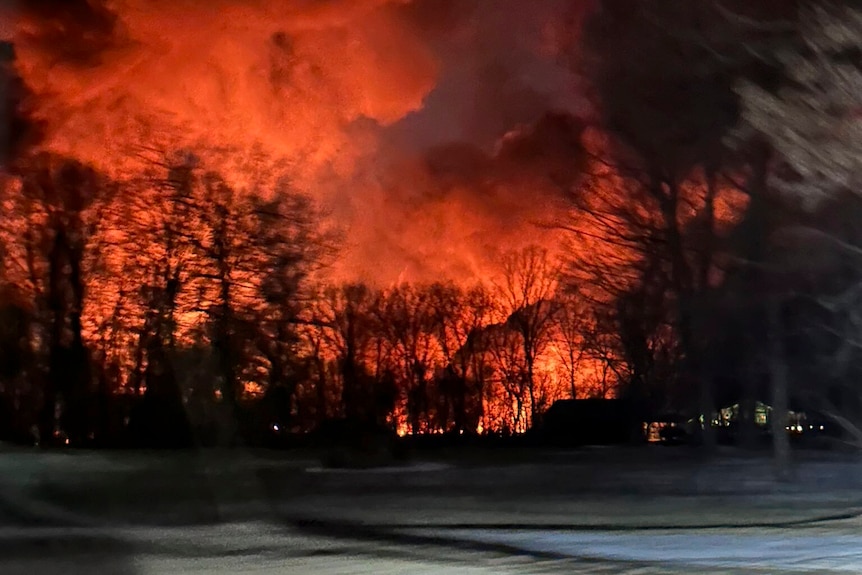 Flames shoot into the night sky behind a farm in Ohio after a train derailment.
