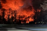 Flames shoot into the night sky behind a farm in Ohio after a train derailment.