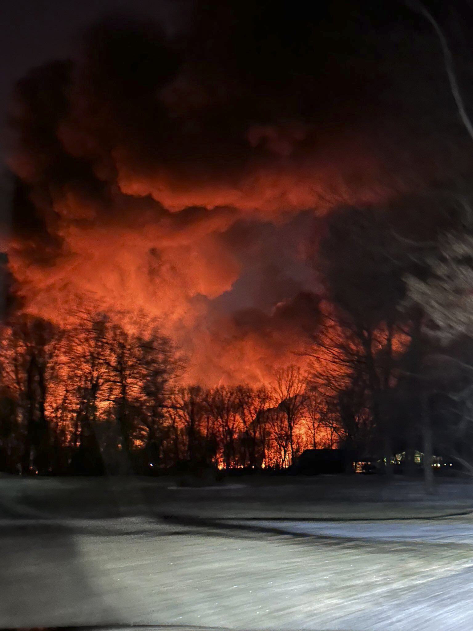 火车出轨后，俄亥俄州一个农场后面的夜空冒出火焰。