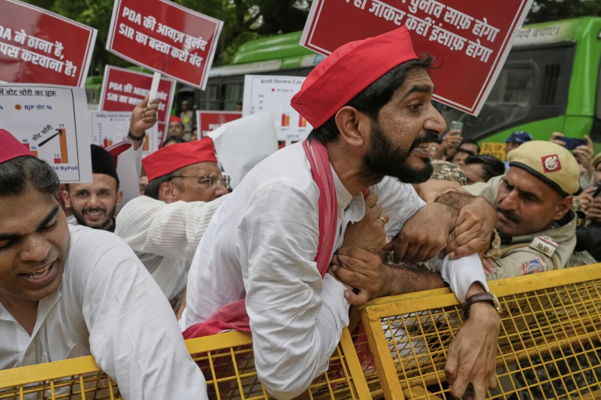 A crowd of protesters in India attempting to break a barricade