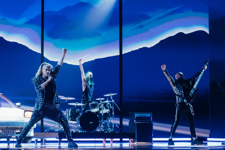 Aussie band Voyager performs in rehearsal against a blue background on stage in Liverpool