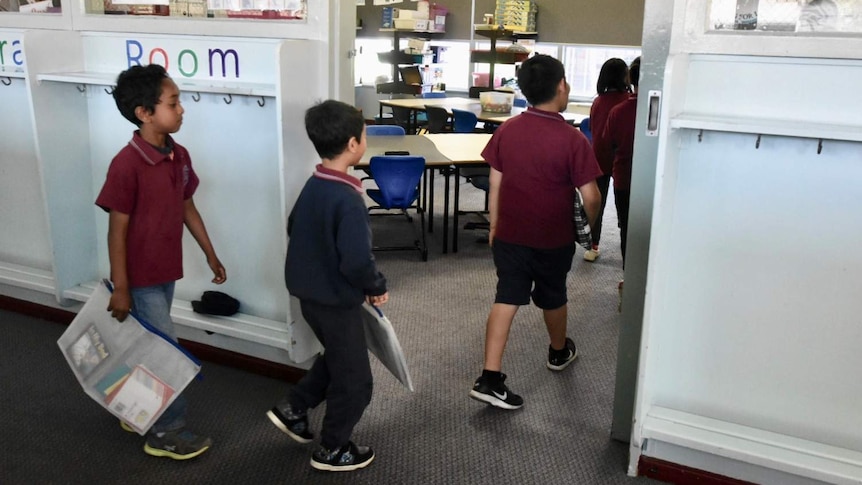 Students walk into their classroom.