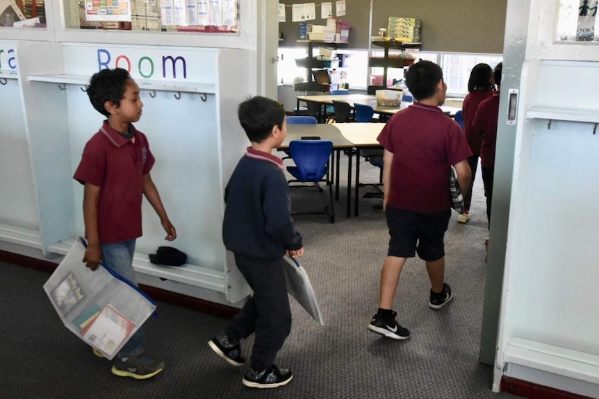 Students walk into their classroom.