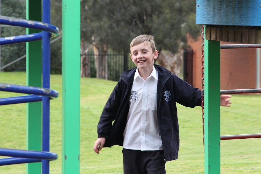 Archer Brady happily playing on the jungle gym at his primary school in Junee in the NSW Riverina.