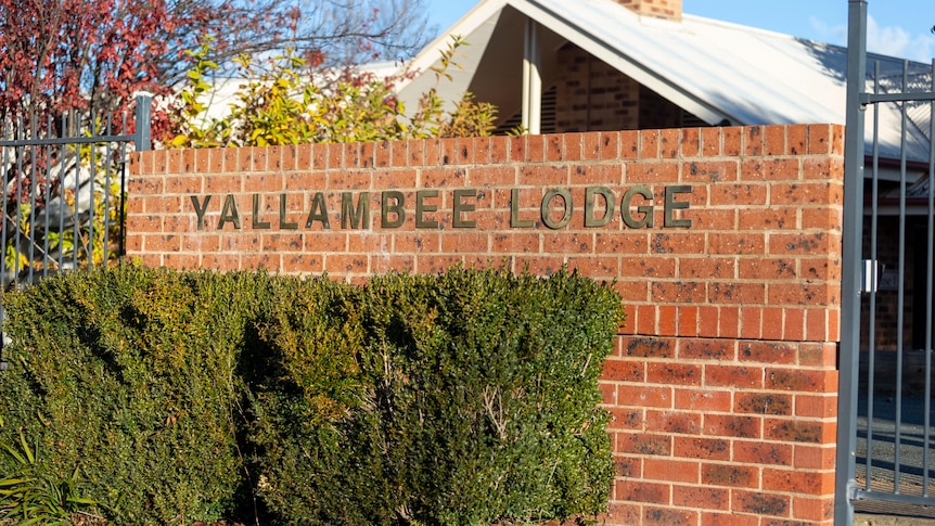 A brick wall out the front fo a residential care facility. It bears the lettering "Yallambee Lodge".