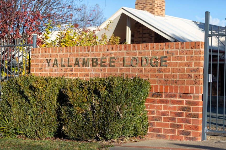 A sign on a wall reading Yallambee Lodge