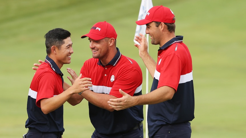 Collin Morikawa celebrates with Bryson DeChambeau and Scottie Scheffler, all smiling