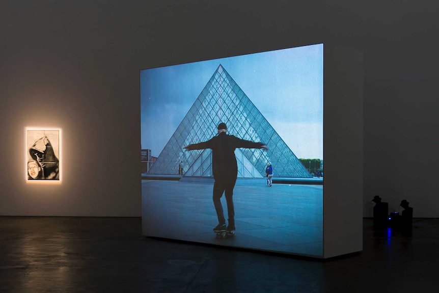 Shaun Gladwell's skateboarding video work is displayed in a gallery.