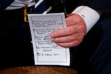 A hand holds a piece of paper with five bullet points on how to speak to students affected by the Florida shootings.