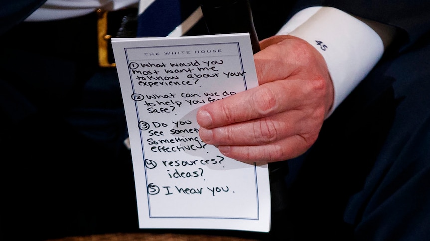A hand holds a piece of paper with five bullet points on how to speak to students affected by the Florida shootings.