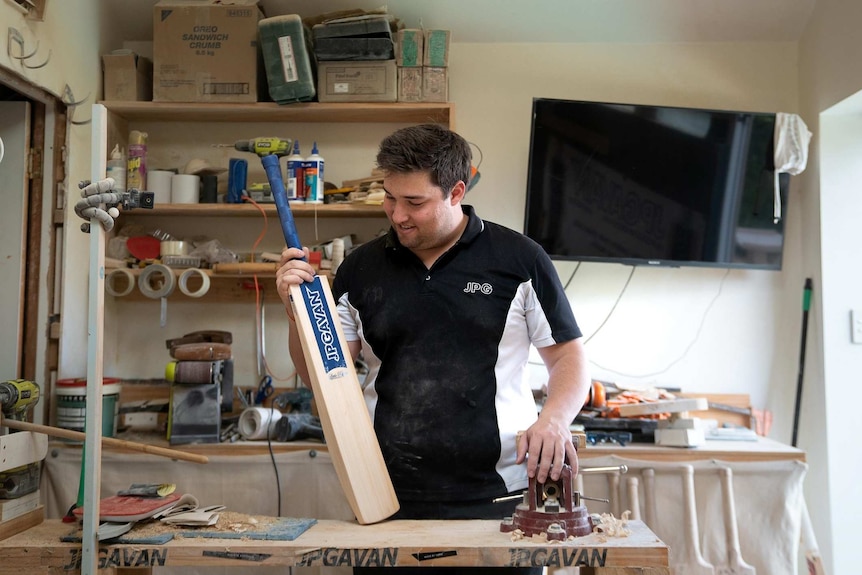 Josh Gavan inspects one of the many bats he takes care of in his capacity as bat fixer to the stars in Sydney.