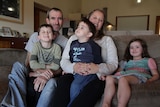 Mark and Holly Jessop on their couch with their three children, Jack, Riley and Pearl.