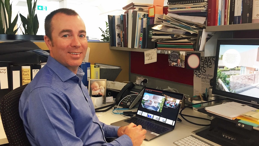 Dr Chris Riedy at his desk in his office.