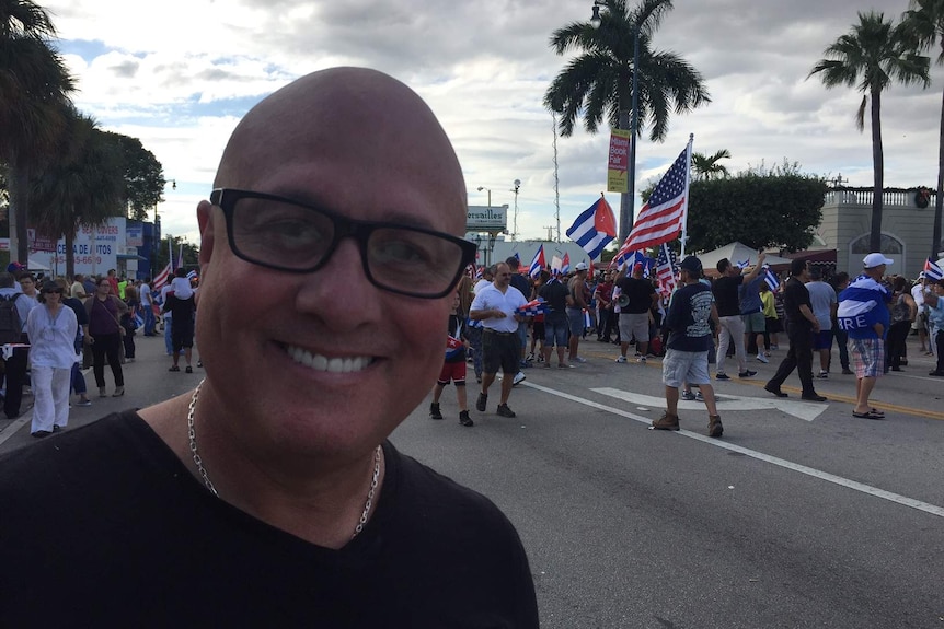 Guillermo Valdez smiles at the camera while festivities continue behind him.