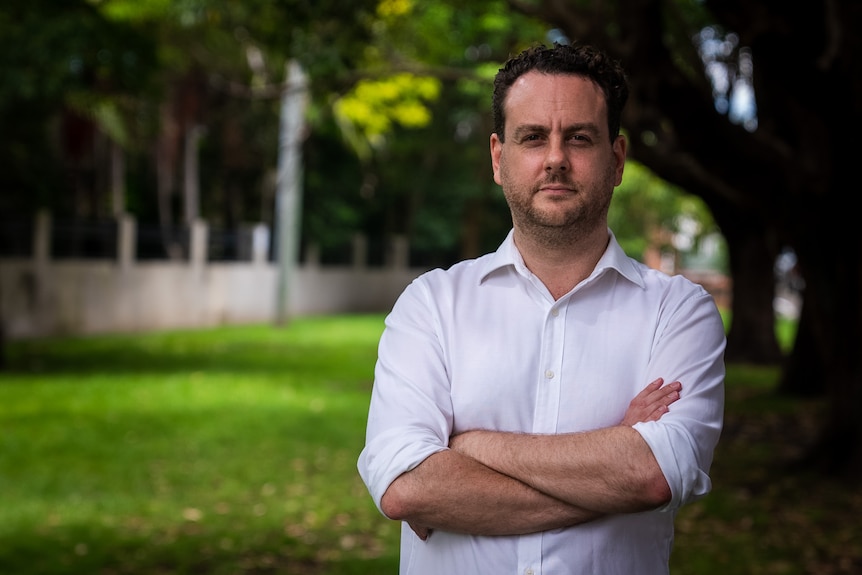 Xavier standing in a white shirt in the park.