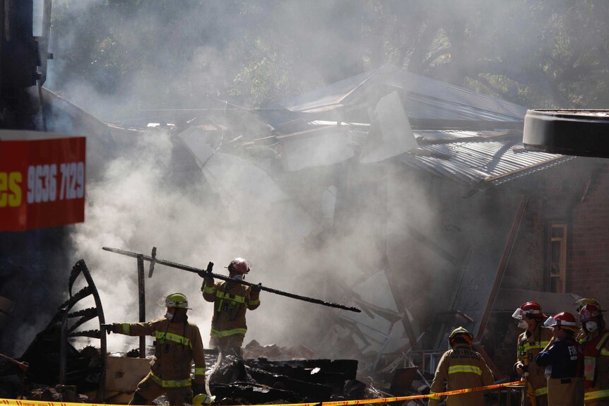 Fire crews sift through the remains of a discount supermarket following an explosion.
