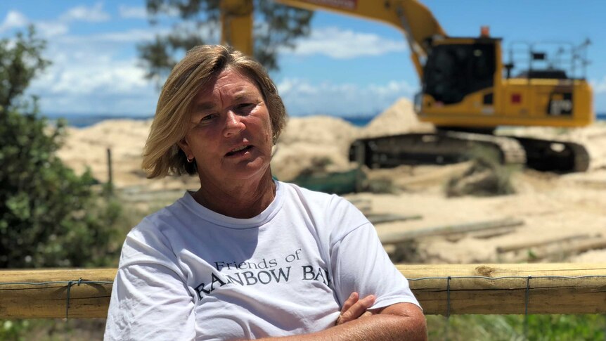 Friends of Rainbow Bay Society spokeswoman Kate Miller standing in front of machinery