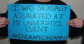 Person holds up a poster about sexual assault at university.