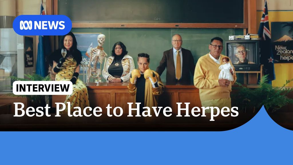 Best Place to Have Herpes: People wearing black and gold in a classroom looking at the camera.