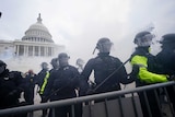 Police stand in front of the Capitol in Washington in a cloud of gas.