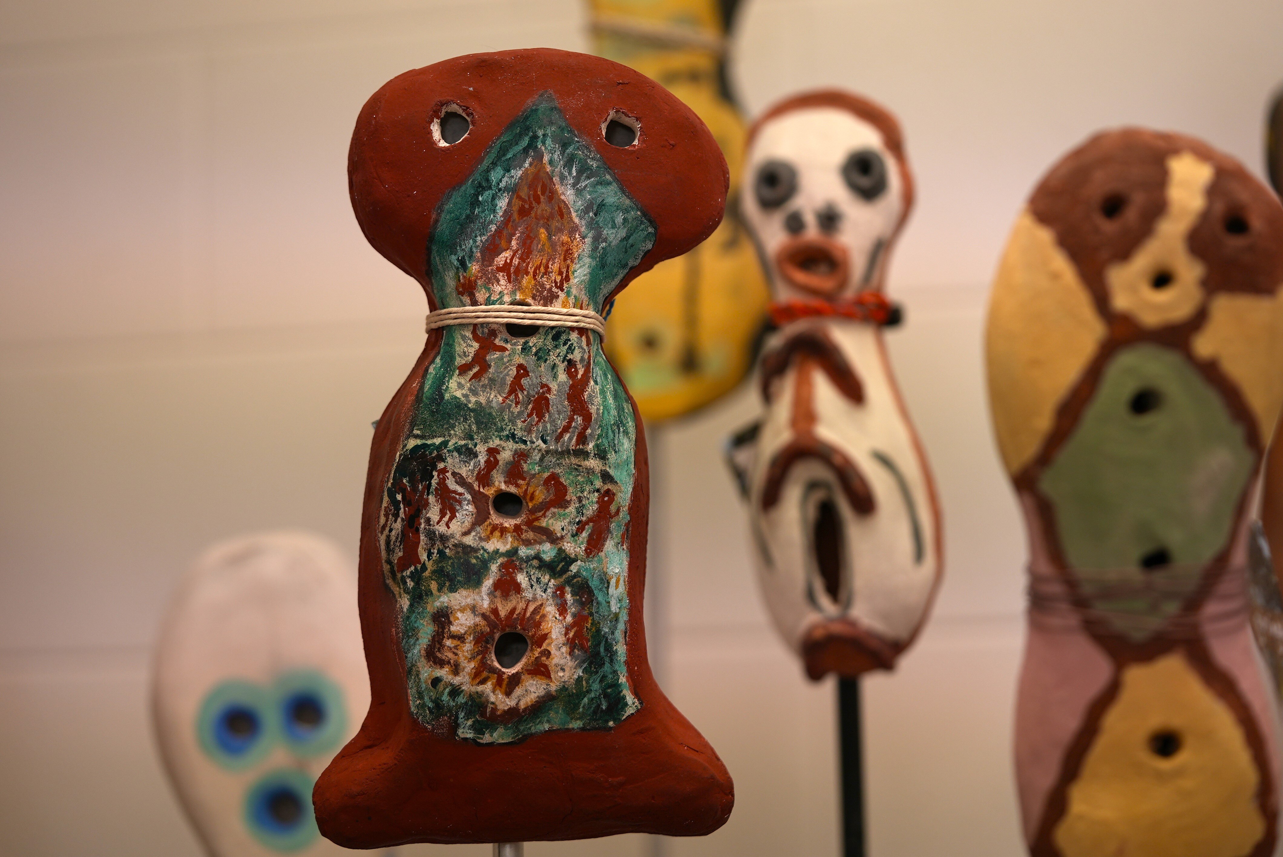 Several brightly coloured clay sculptures in a gallery.