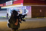 Police officer holding aiming a weapon in Ferguson, Missouri.