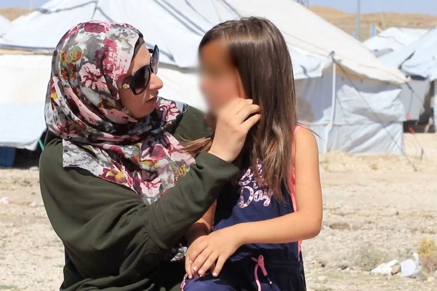 A woman talks to a little girl.