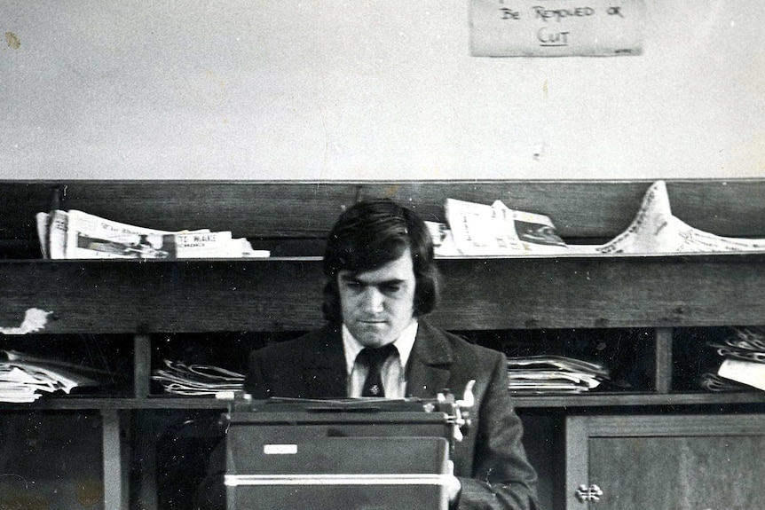 Black and white photo of Cassidy sitting at typewriter.