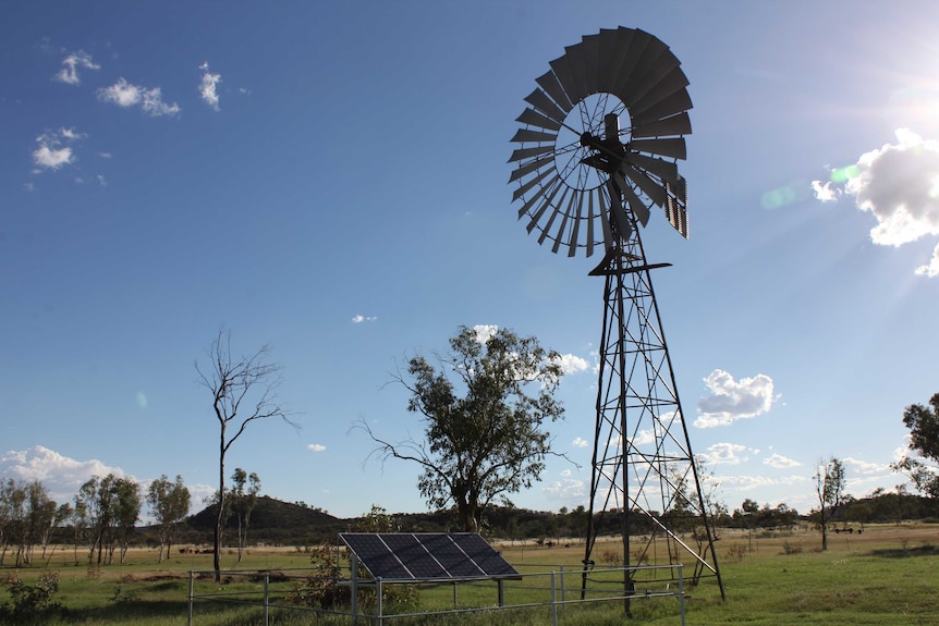 A windmill on Undoolya station with a new solar panel beside it