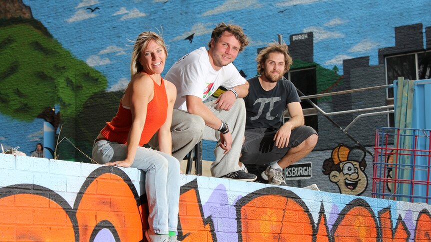 Charlie Truscott, Antony Smith and Matt Sanderson sit on a brick wall.