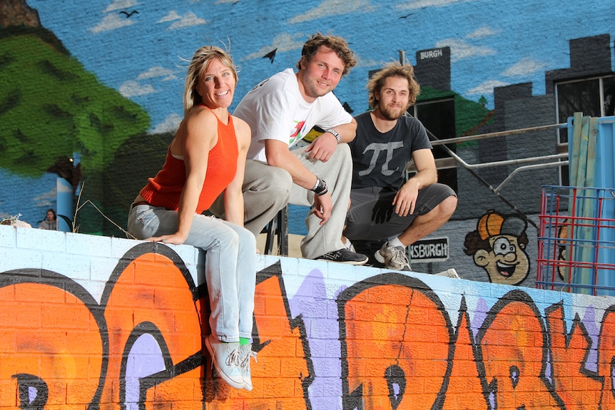 Charlie Truscott, Anthony Smith and Matt Sanderson sit on a brick wall.