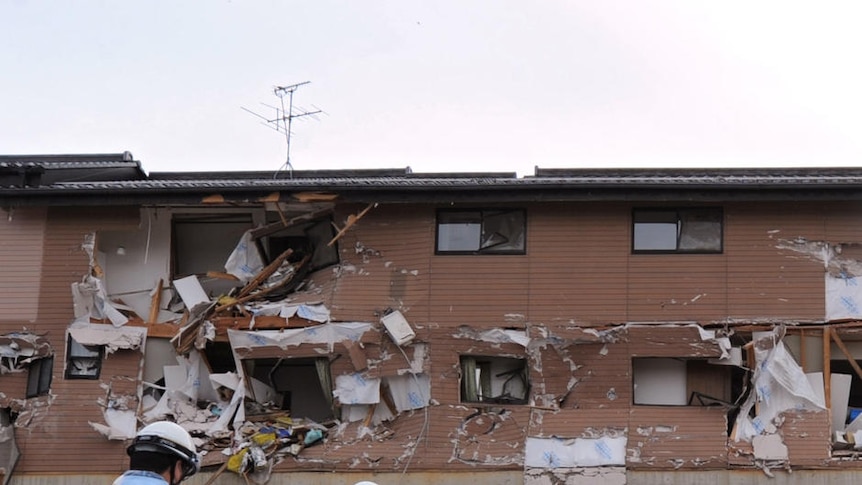 Victims are placed outside a devastated building in Miyagi Prefecture.