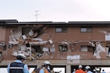 Victims are placed outside a devastated building in Miyagi Prefecture.