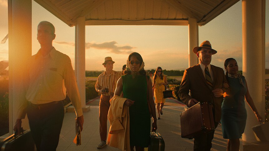 Wide colour still of Regina King walking undercover at sunset near airport landing strip in film If Beale Street Could Talk.