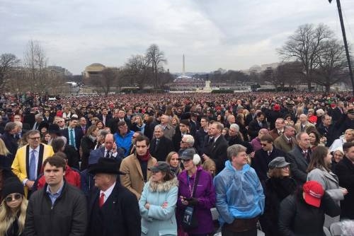 A crowd stands on the cloudy inauguration day waiting for the new President's speech.
