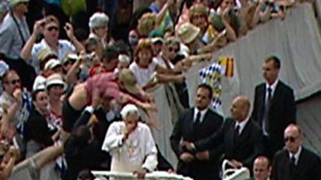 Incident: The man (in pink at left) jumps a barricade and is overpowered by papal bodyguards