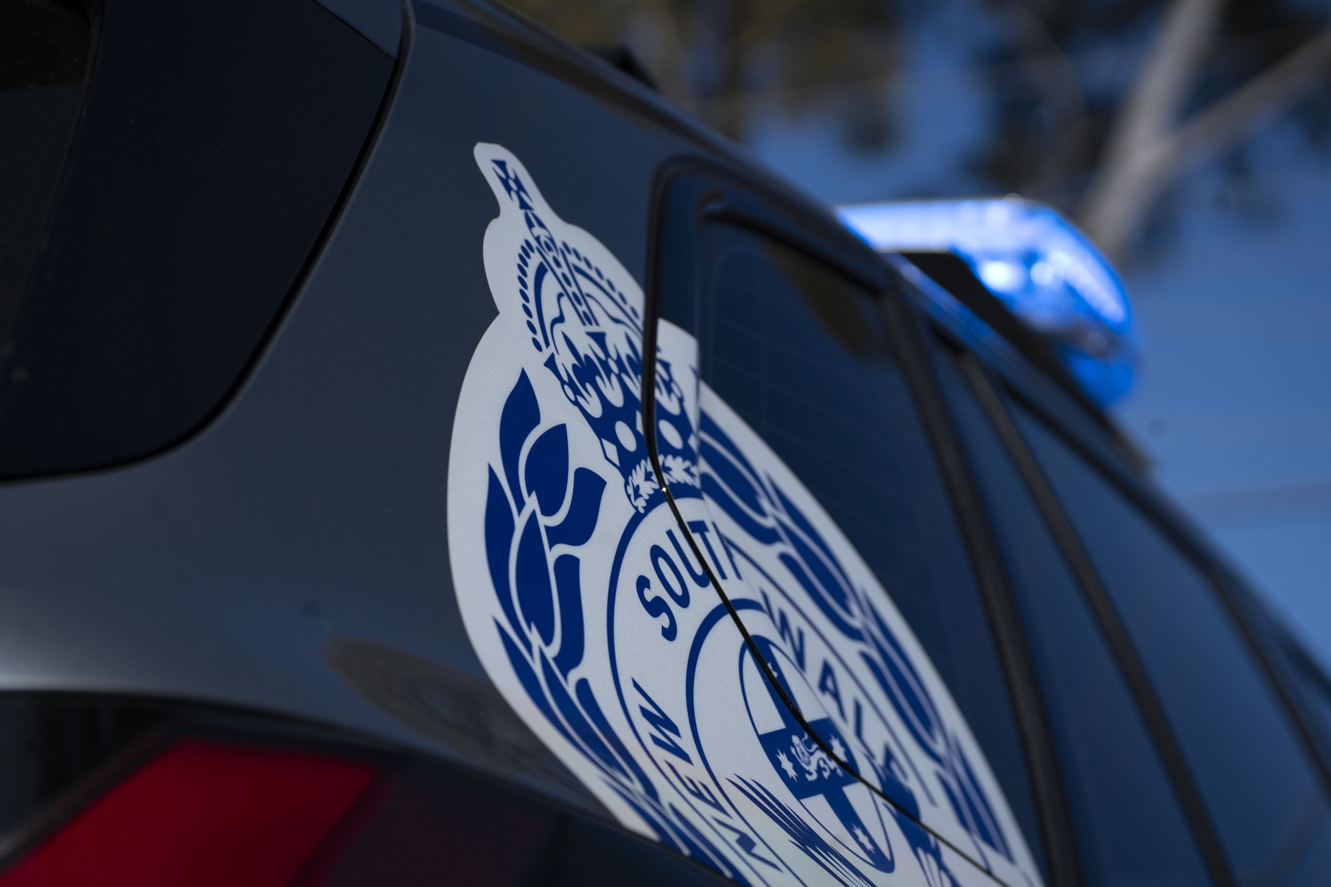 NSW Police logo on cop cars and crime scene tape generics on a sunny day
