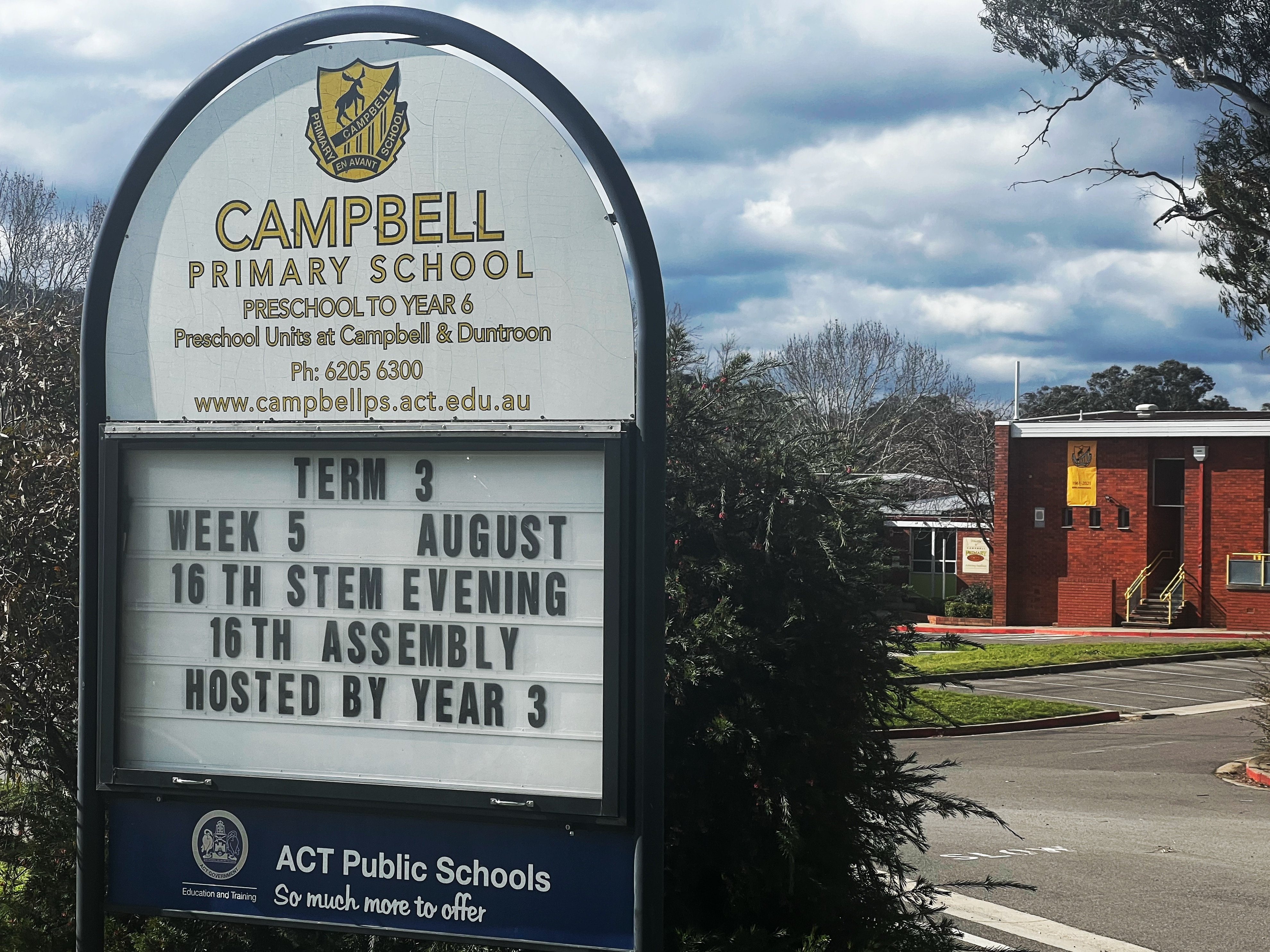 A primary school with a noticeboard out front that reads "Campbell Primary School".