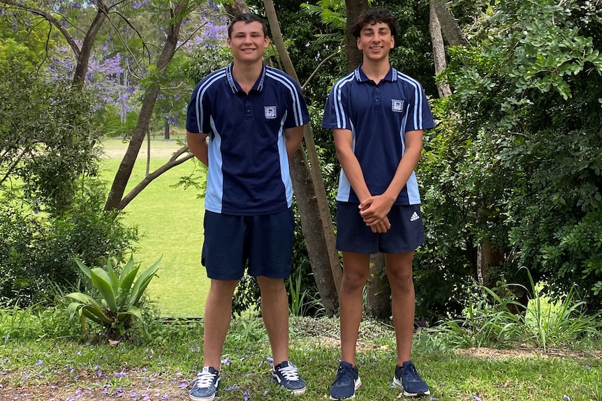 Two teenagers in school uniform under trees