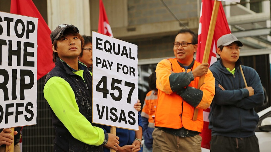 A group of 457 visa holders are protesting outside building site in Braddon demanding equal pay for work.