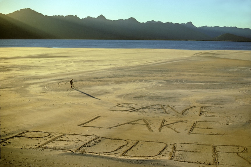 A beach with the words 'Save Lake Pedder.'