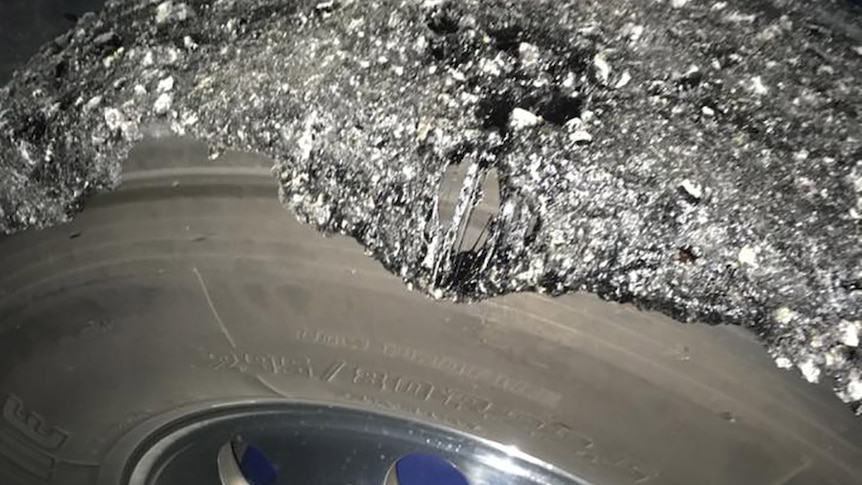 Road bitumen coating the tyre of a truck