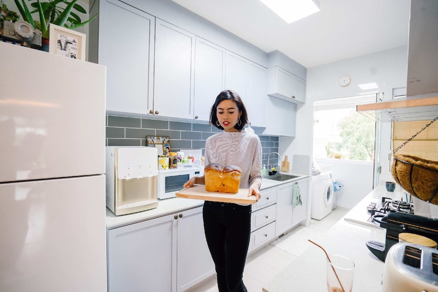 Person walking with a tray of bread that she's just baked